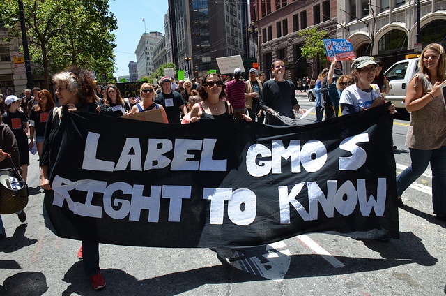 Protesters hold signs to support the labelling of genetically modified foods.